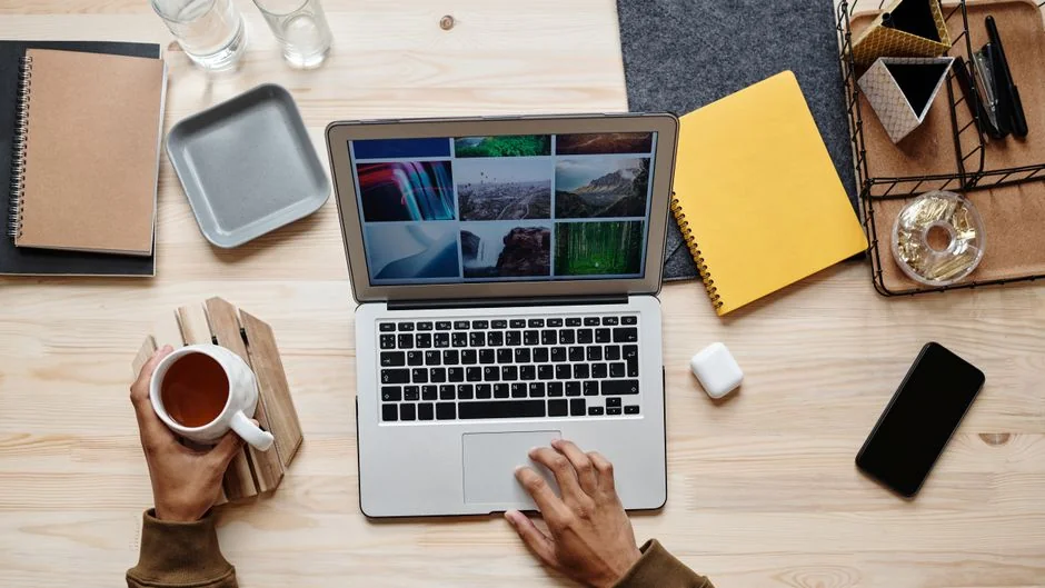 A cozy office setup featuring Christmas decor, a mug, and a laptop screen displaying a website.